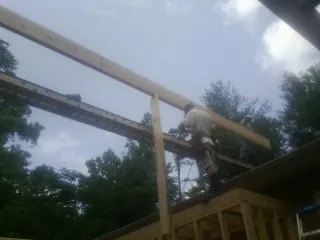 Carpenter setting a ridge beam over a new addition frame — Ice Dam Removal by Roofing Brothers in Rochdale