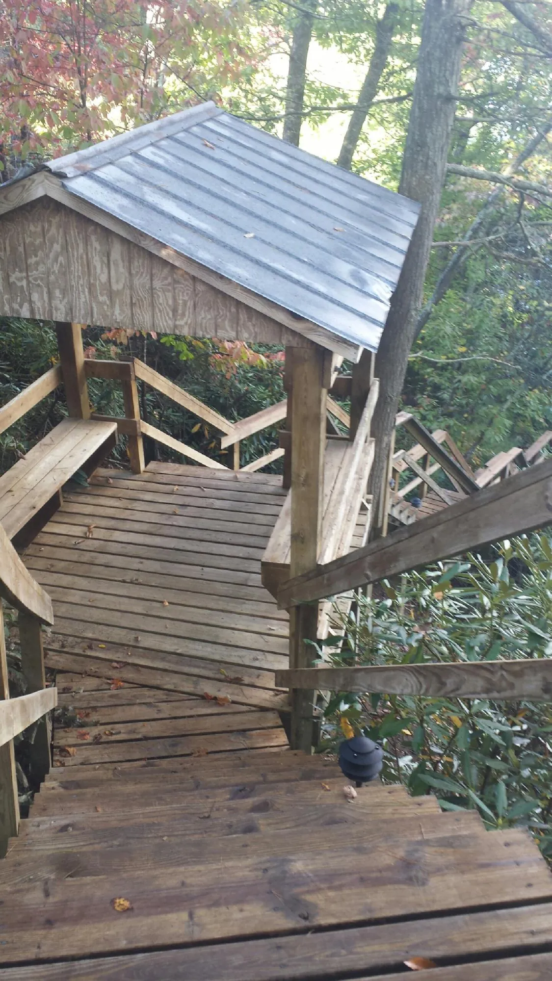 Metal roofed shelter over wooden steps on a wooded walkway — Skylight Repair & Installation work by our crew in Rochdale