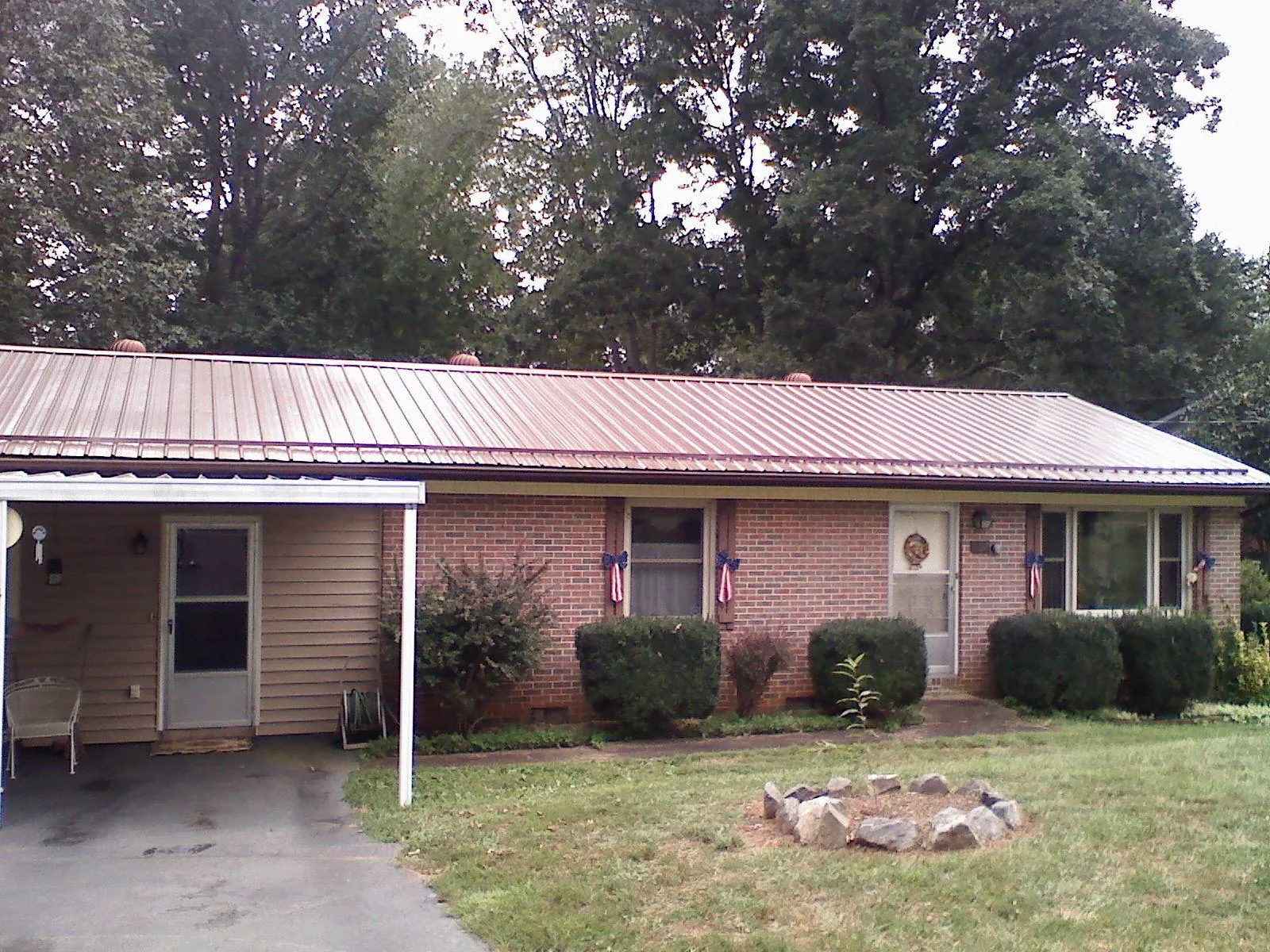 Bronze metal roof and carport on a brick ranch home — Roof Repair work by our crew in Rochdale